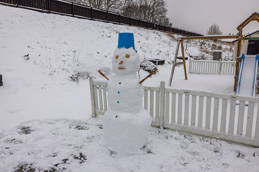 View of snowman made by children in winter garden. Sweden.