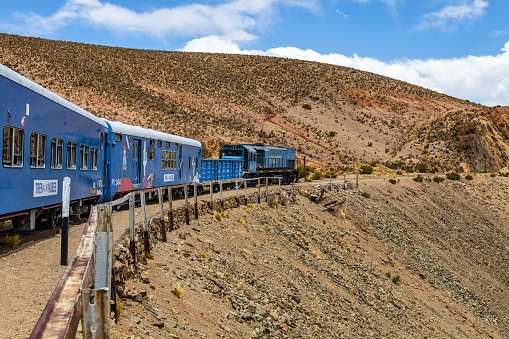 San Antonio de los Cobres, Argentina, November 9, 2019: The so called Train to the clouds (Spanish: Tren a las Nubes) goes through the mountain pass near to the famous viaduct La Polvorilla in the Andes at an altitude of 4300 meters. The Train to the clouds is a tourist attraction.