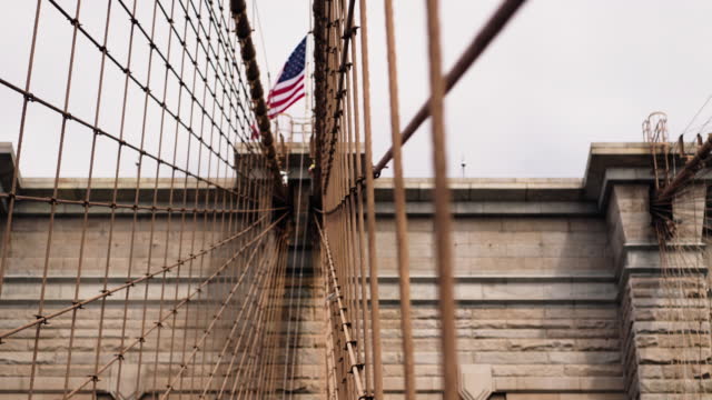 Close-up of Brooklyn Bridge Towers with American National Flag on the Top