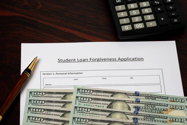 Student loan forgiveness application with cash money. Student debt crisis, tuition assistance and financial aid concept. stock photo