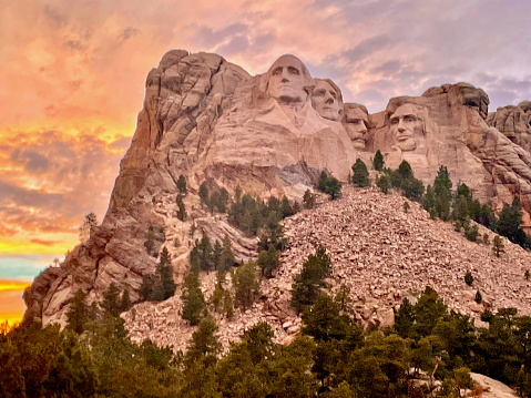 Keystone, South Dakota, USA - July 5, 2022: The sun sets behind Mount Rushmore on a warm summer evening at Mount Rushmore National Park.