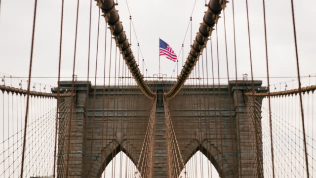 Close-up of Brooklyn Bridge Towers with American National Flag on the Top