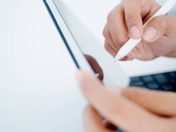 istock Close up white electronic pen or pencil in hand, write, draw or sign on blank digital tablet screen, computer isolated on white background. Business and technology concept. Working with tech device. 1418793796