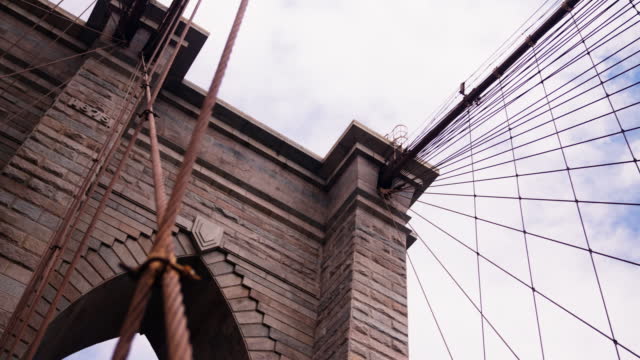 Bottom Up View of Brooklyn Bridge Towers with American National Flag on the Top