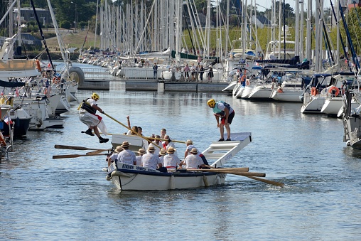 Vannes, France, August 28, 2022 : Fall in the water of one of the competitors of the nautical jousts of Vannes in Brittany