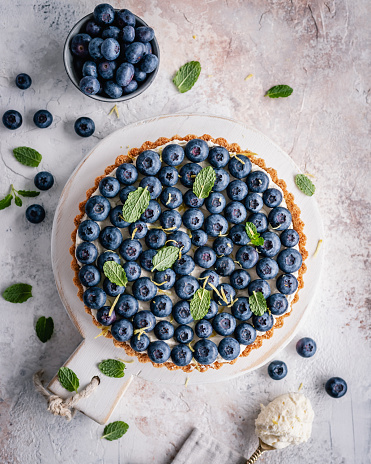 Overhead view of a blueberry tart decorated with fresh mint leaves
