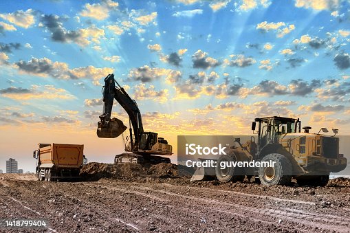 istock Excavators working on construction site at sunset 1418799404