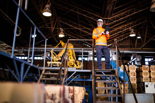 istock Industrial worker with radio communication and tablet computer walking through the industry manufacturing factory. 1418800028