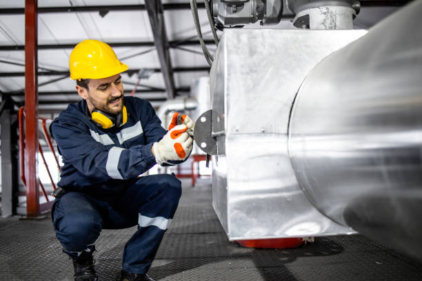 istock Heating plant worker doing quality control of water boiler. 1418801611