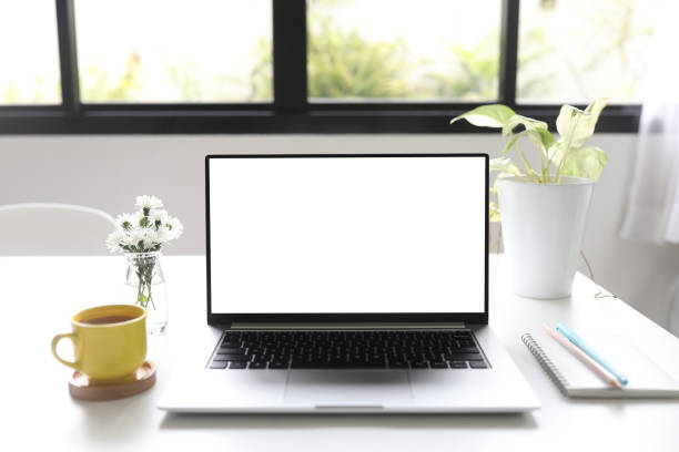 istock Laptop and yellow coffee cup and white flowers on white table indoor work from home 1418801830