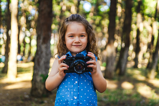 Little girl learns to take pictures with old analog camera