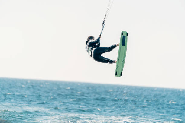 istock young latino flying in the air doing kitesurfing or kiteboarding 1418808983