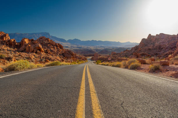 In Valley of Fire the road is winding and running through the red rock desert landscape. Seen in Nevada, USA, a hot day in the summer.