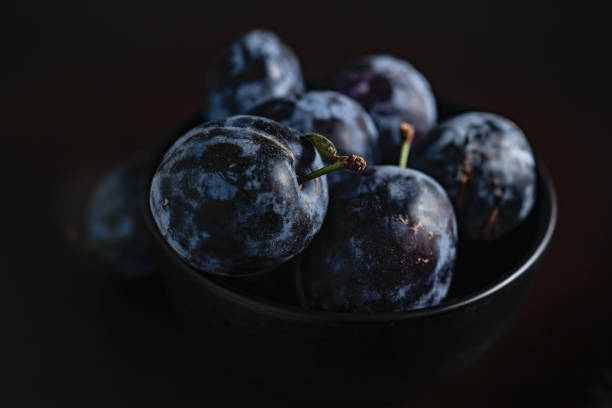 istock Plums in a dark bowl on a black background 1418814189