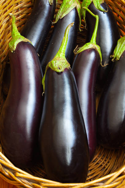 istock Fresh raw purple eggplants in a straw basket. 1418814191