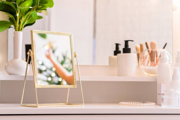 istock Reflection of christmas tree, light bulbs, in table mirror on woman dressing table with make up accessories 1418817820