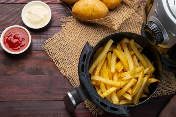 hausgemachte bratkartoffeln in einem fritteusentopf - kartoffel grundnahrungsmittel stock-fotos und bilder