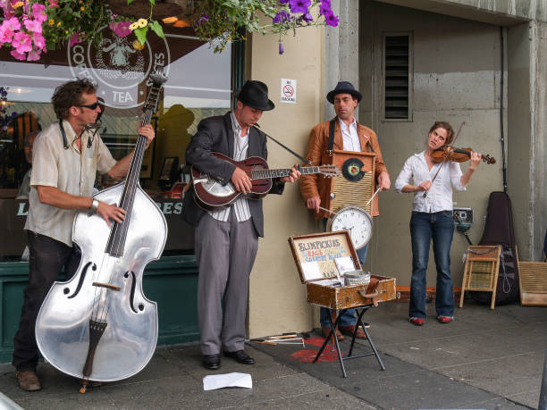 New Orleans, Louisiana - May, 11 2010: A street busker plays music with a guitar and harmonica next to the Mississippi River in New Orleans' French Quarter