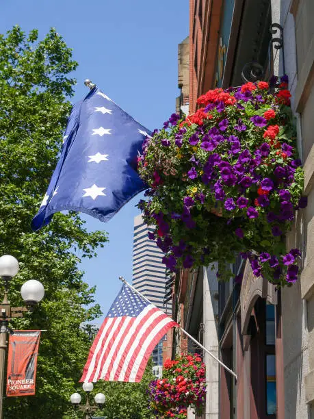 America flags and hanging flower baskets on side of building in Pioneer Square, Seattle, USA.