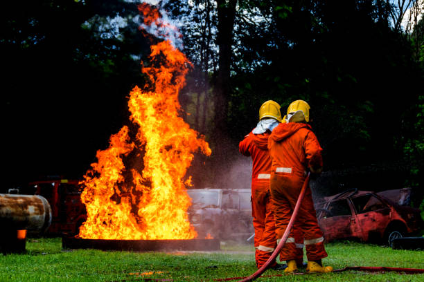 istock Firefighter Concept. Fireman using water and extinguisher to fighting with fire flame. firefighters fighting a fire with a hose and water during a firefighting training exercise 1418820701