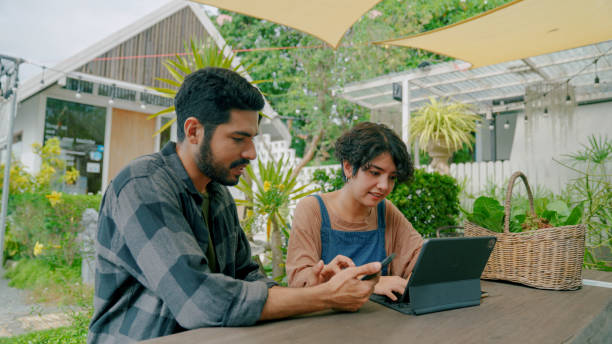 jovem casal asiático ajudando uns aos outros a gerenciar finanças para seu próprio negócio. - budget green business finance - fotografias e filmes do acervo