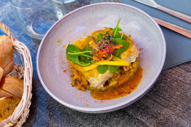 istock Codfish baked with curry and served with quinoa and greens 1418823475