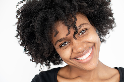 Close-up of cheerful African American woman looking at camera. Happy female model wearing black T-shirt smiling at camera. Happiness concept