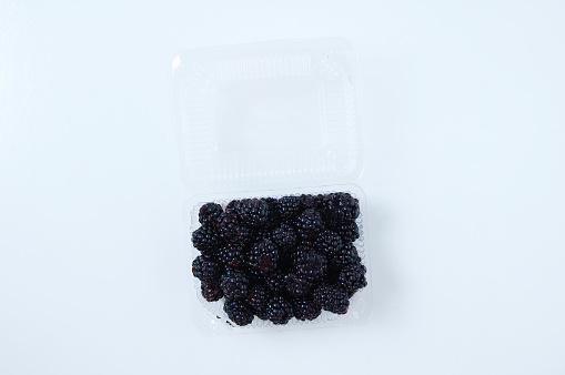 Blackberries, raspberries and blueberries in small bowls on a table - from above