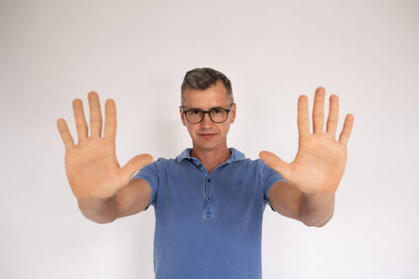 istock Portrait of mature man making stop gesture with two palms 1418828718