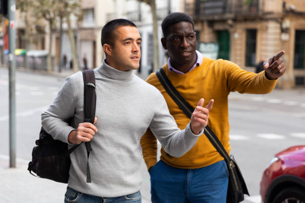 istock Two men tourists point finger sightseeing at street 1418831241