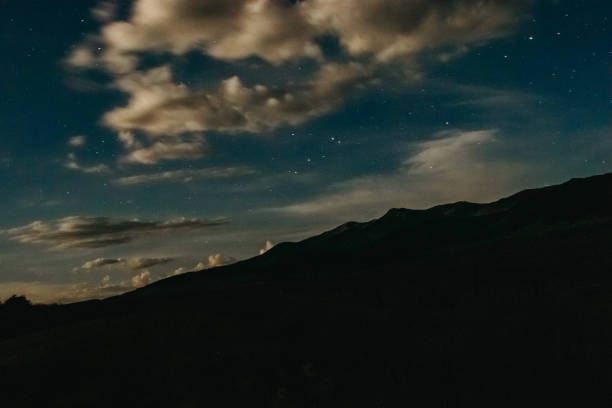 istock Mountain range at night with stars and clouds 1418831248