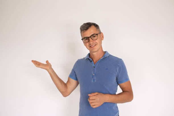 istock Attractive man in glasses pointing copy space 1418832336