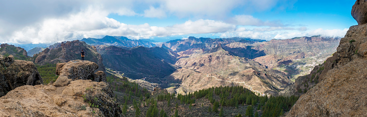 Panoramic view from Roque Nublo plateau on central volcanic mountains, Caldera and Barranco de Tejeda and Roque Bentayga rock with standing woman figure. Gran Canaria, Canary Islands, Spain