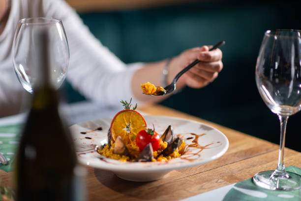 istock A woman eating seafood risotto 1418842082