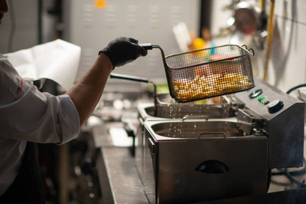 Chef frying potatoes in restaurant kitchen stock photo