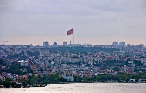 Balat, eminönü and karaköy view, there are lots of people on the bridge, lots of them are fishing, and beyond the bridge you see the golden horn view with ottoman mosques in a cloudy summer day.