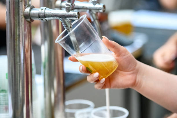 Pouring beer into a disposable cup stock photo