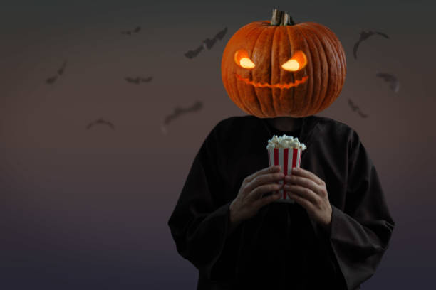 hombre con cabeza de calabaza y con palomitas de maíz para halloween - horror monster spooky movie fotografías e imágenes de stock