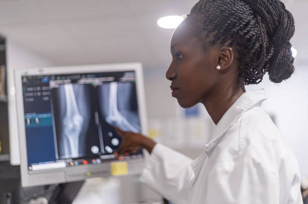 doctor radiologists  working together Young female doctor examining radiology results examining x ray stock pictures, royalty-free photos & images