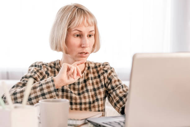 istock Business Woman listening educational lecture on computer, watching webinar, studying on online courses, writing notes in paper copybook, e-learning concept 1418852696