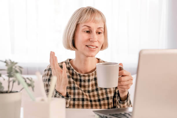 istock Business Woman listening educational lecture on computer, watching webinar, studying on online courses, writing notes in paper copybook, e-learning concept 1418853474