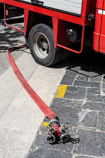 Rhodes, Greece - May 27, 2022: Fire truck and fire hose in the street in the town of Rhodes island, Greece.