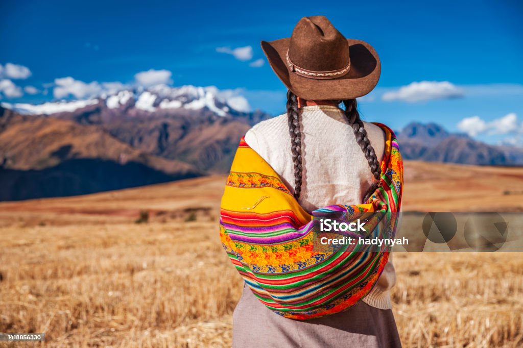 Peruvian woman in national clothing looking at Andes, The Sacred Valley Peruvian woman in national clothing admiring view of Andes in The Sacred Valley. The Sacred Valley of the Incas or Urubamba Valley is a valley in the Andes  of Peru, close to the Inca  capital of Cusco and below the ancient sacred city of Machu Picchu. Cusco City Stock Photo