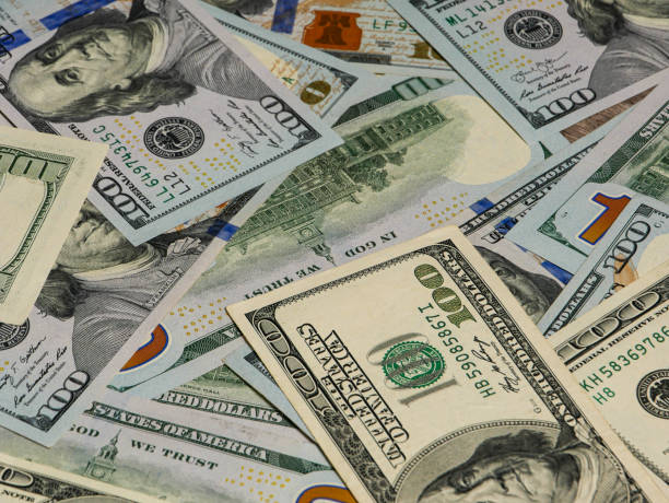 istock Large pile of hundred dollar bills in background view. 1418880598