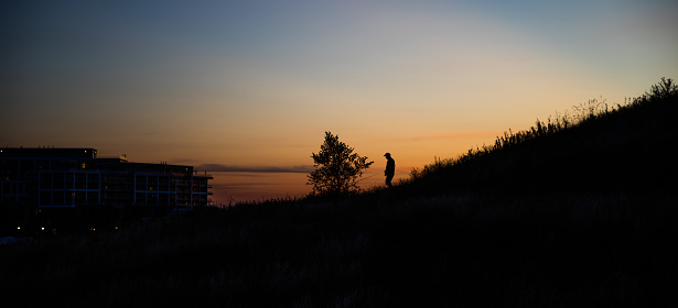 Toronto, ON, Canada - August 27, 2022: A man is walking down the hill at Toronto's Downsview Park in the evening.