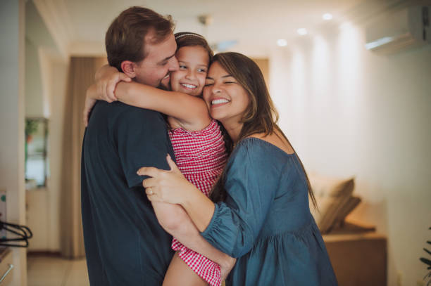 padres e hijas acurrucados en la sala de estar - happy family home fotografías e imágenes de stock