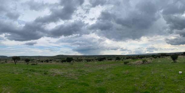 istock Panoramic view of mountains and grass with dark clouds and blue sky. 1418898026