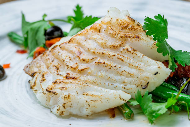 木製のテーブルマクロクローズアップにインゲンをプレートに載せたmorueグリル - prepared fish fish grilled close up ストックフォトと画像