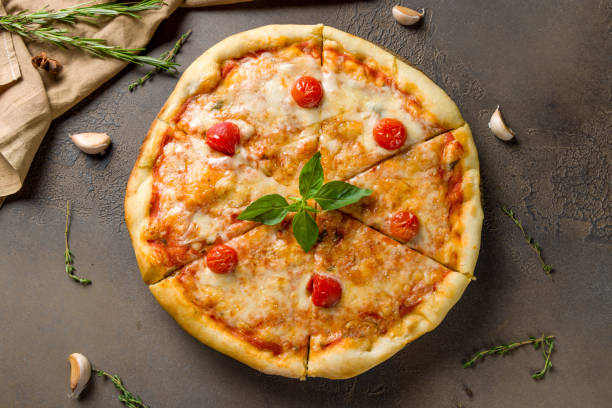 istock Italian pizza Margherita with cheese, tomatoes and basil on brown table top view 1418901213