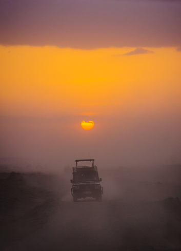 4x4 Jeep kicking up dust on a safari when sunset view in Amboseli National Park, Kenya